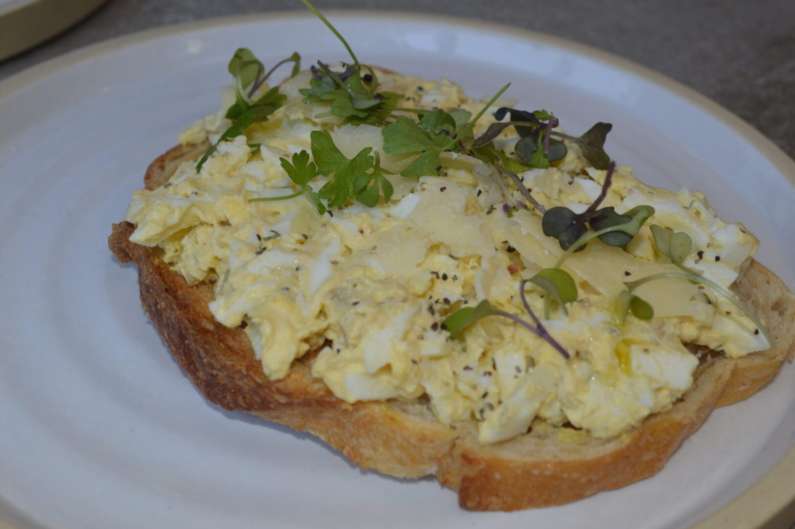 A piece of bread with scrambled eggs on it.