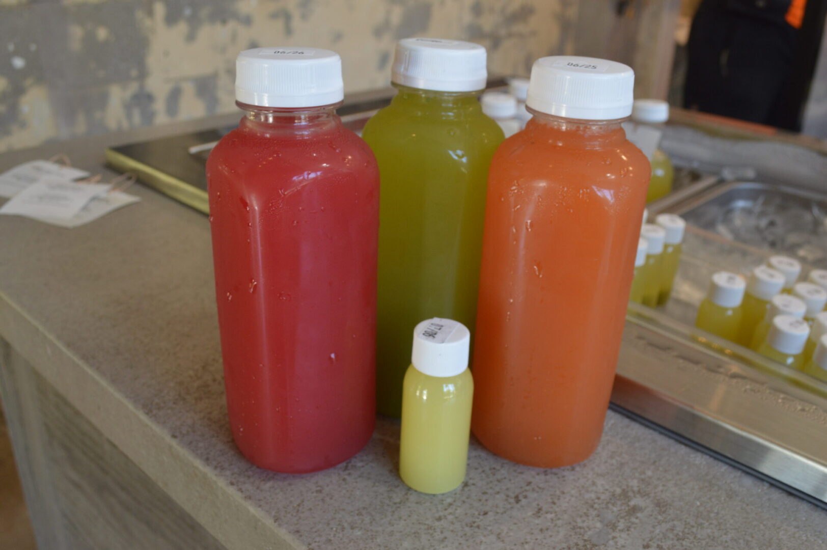 Four bottles of juice are sitting on a counter.