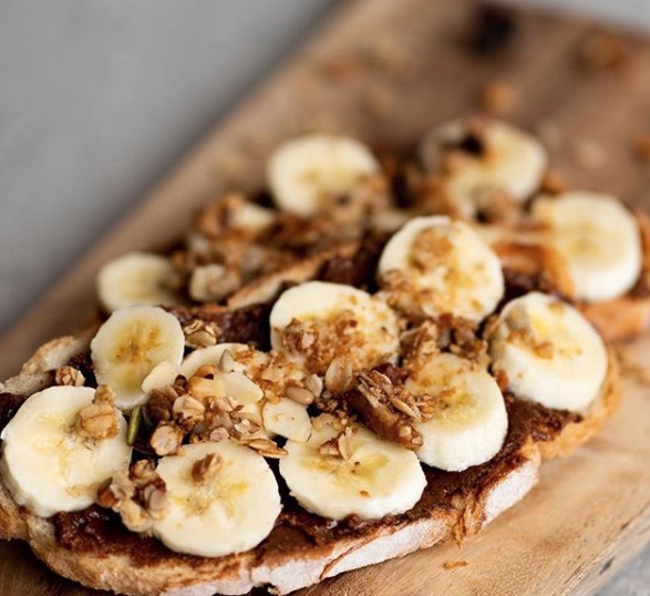 A piece of bread topped with bananas and nuts.